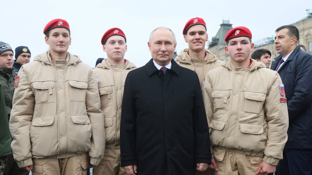 Dieses von der staatlichen russischen Agentur Sputnik verbreitete Foto zeigt den russischen Präsidenten Wladimir Putin (Mitte) mit jungen Kadetten während einer Kranzniederlegung am Denkmal auf dem Roten Platz am 4. November 2023.