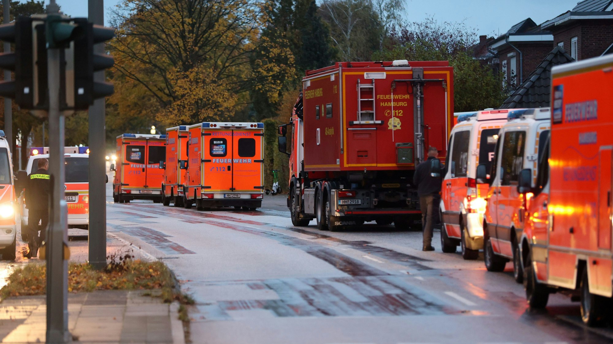 Einsatzkräfte der Feuerwehr stehen auf der Alsterkrugchaussee während eines Einsatzes auf dem Hamburger Flughafen in Bereitschaft. Helfer standen für den Notfall bereit.