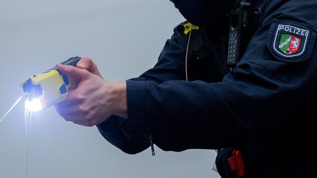 Ein Polizeibeamter demonstriert einen Schuss mit einem Distanzelektroimpulsgerät (DEIG oder auch Taser).