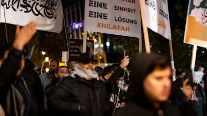 Schilder und Fotos werden gezeigt bei der Kundgebung „Gaza unter Beschuss – gemeinsam gegen das Unrecht“ am Freitagabend in Essen.