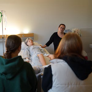 Pflegepädagogin Miriam Strauch zeigt Schülerinnen anhand der Übungspuppe Terry, was in ihrem Beruf wichtig ist.
