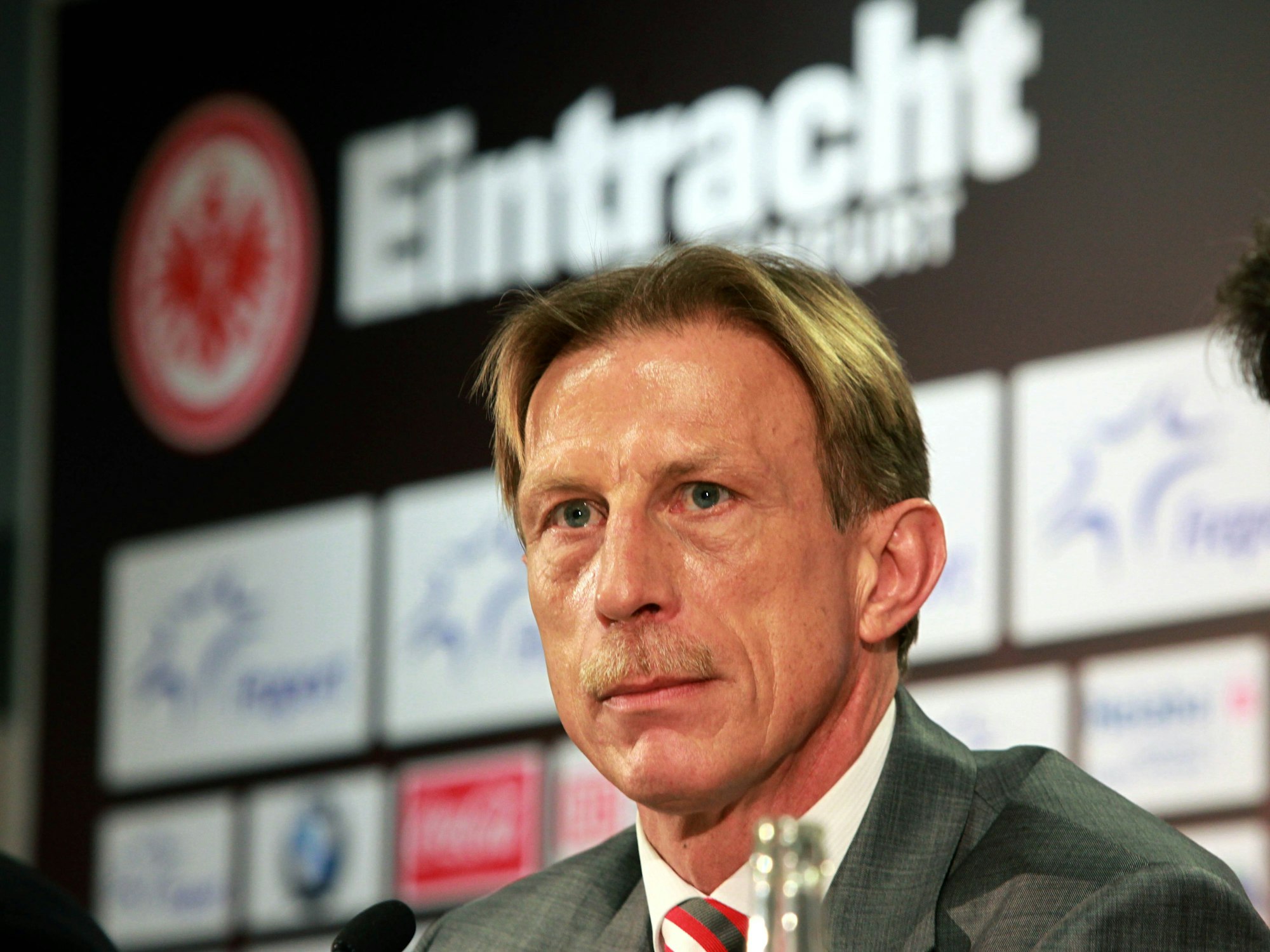 Christoph Daum sitzt auf einer Pressekonferenz zu seiner Zeit bei Eintracht Frankfurt.