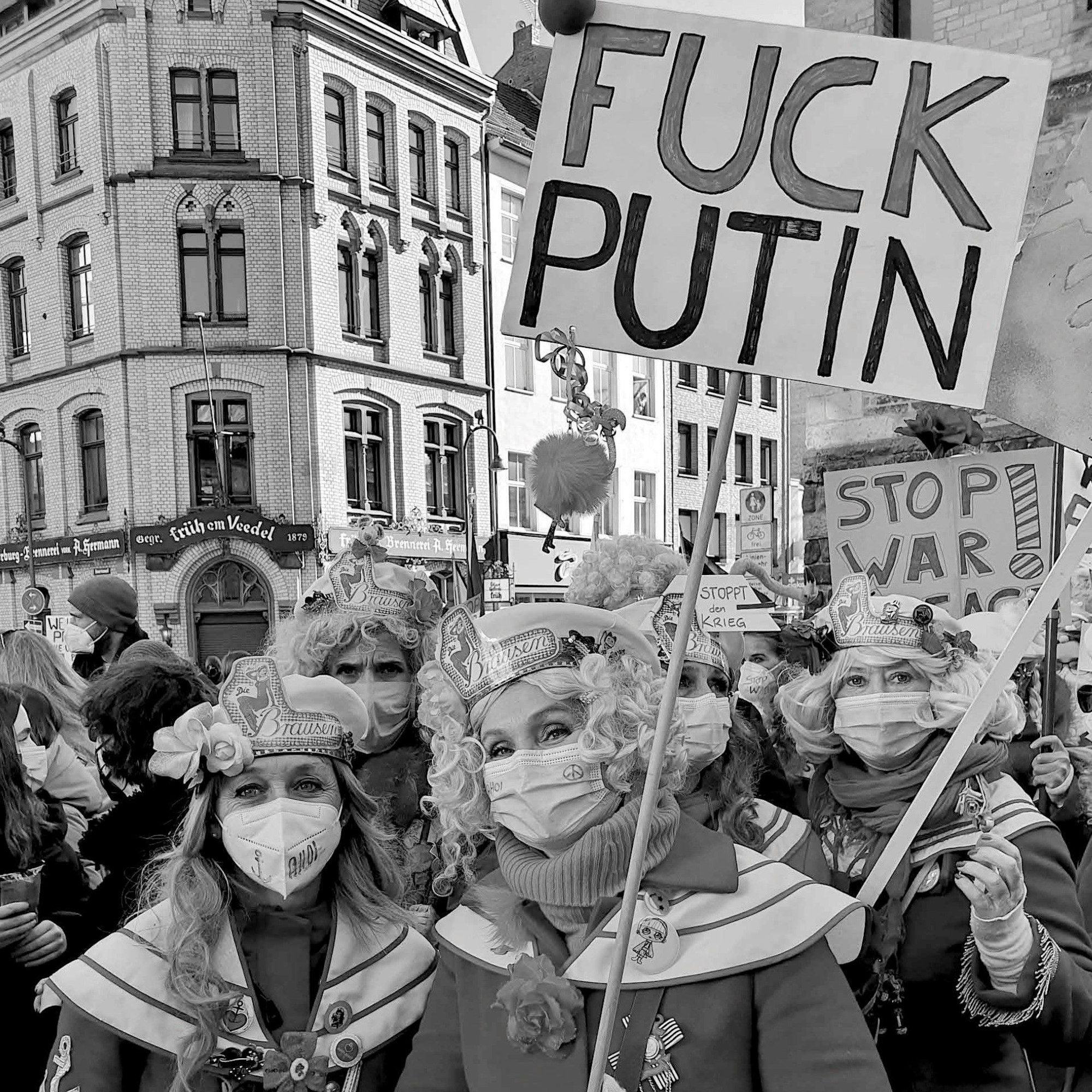 Verkleidete Frauen halten ein Schild mit der Aufschrift „Fuck Putin“ hoch.