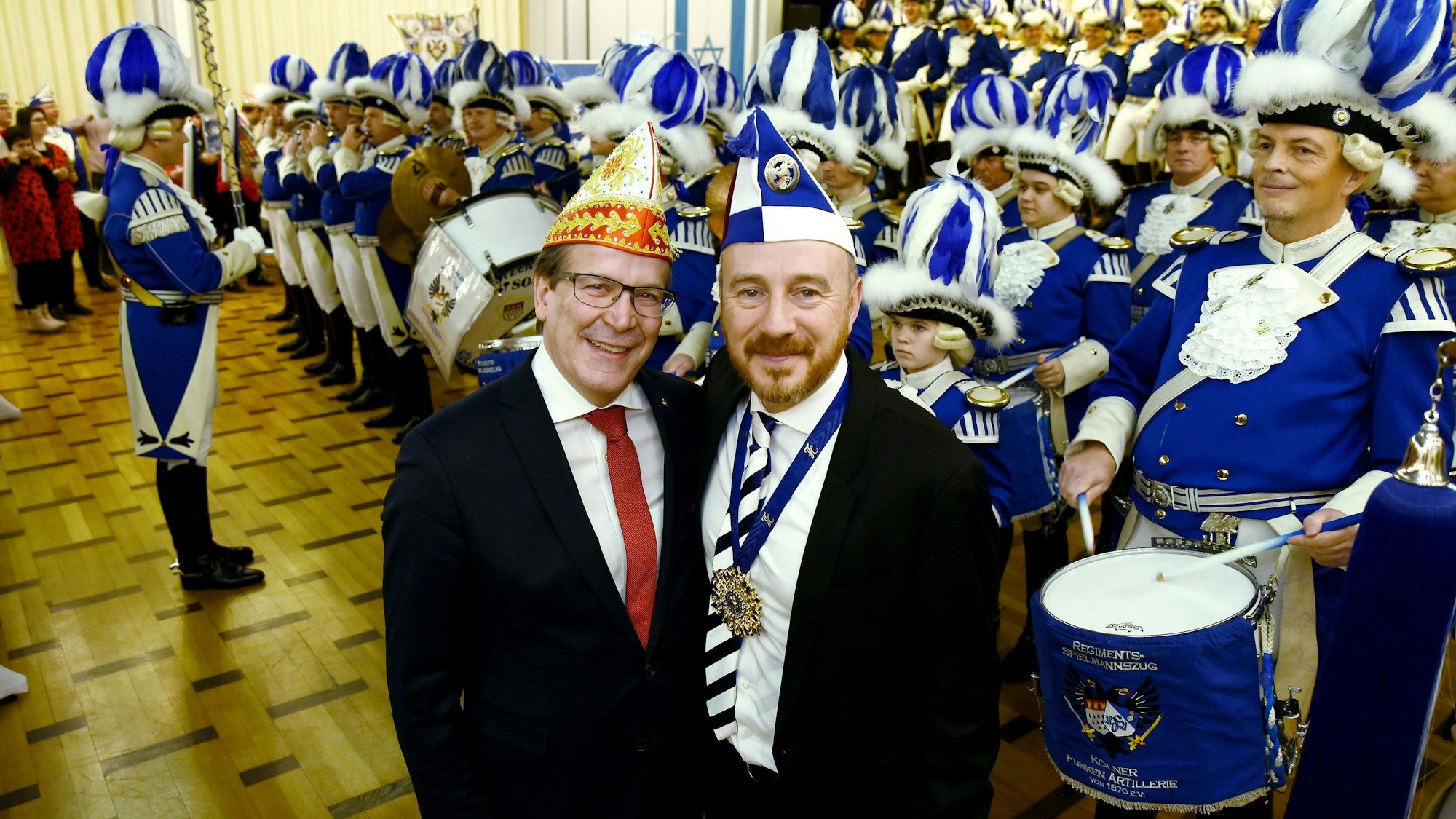 Festkomitee-Präsident Christoph Kuckelkorn mit Aaron Knappstein von den Kölschen Kippa Köpp in der Synagoge, im Hintergrund ein Trommlerkorps von Karnevaliste.