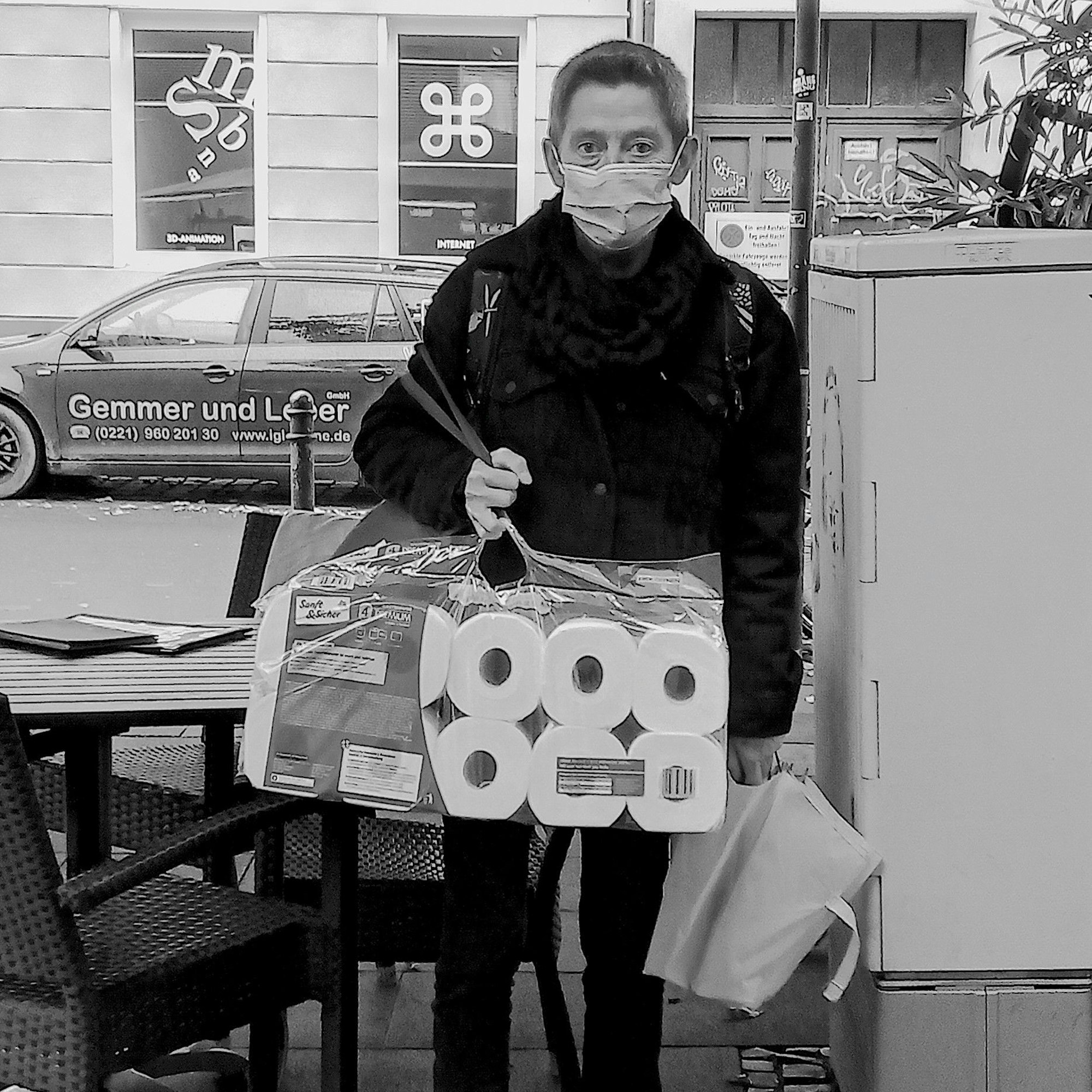 Eine Frau in Köln mit einer Packung Klopapier.
