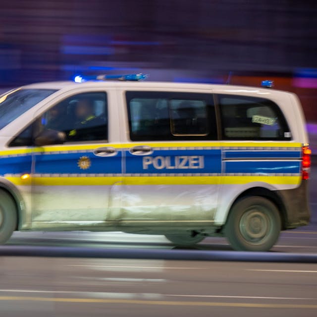 Ein Polizeiauto fährt mit Blaulicht zu einem Einsatz (Aufnahme mit Wischeffekt und Langzeitbelichtung).