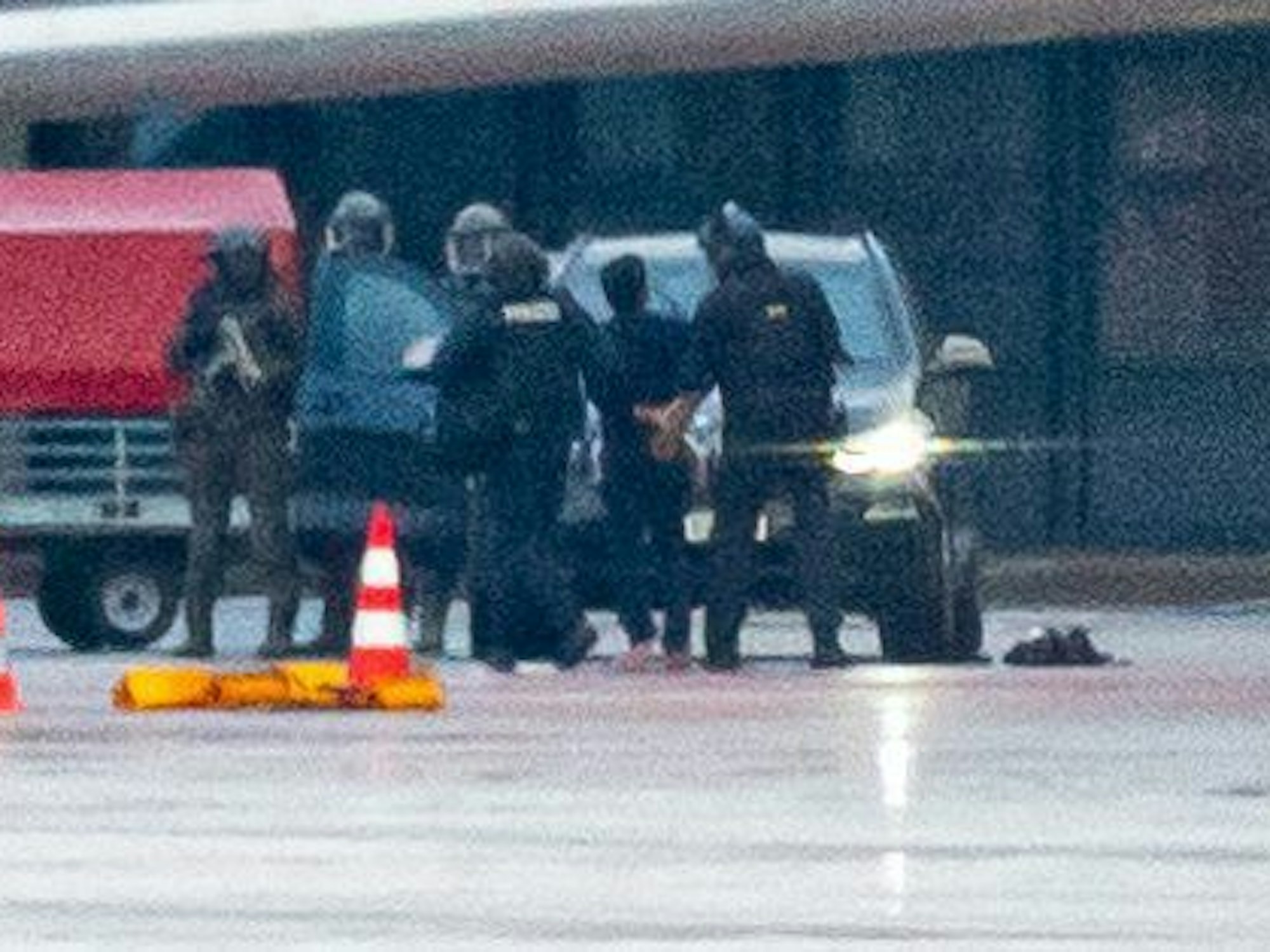 Ein Mann wird auf dem Flughafen von der Polizei weggeführt.