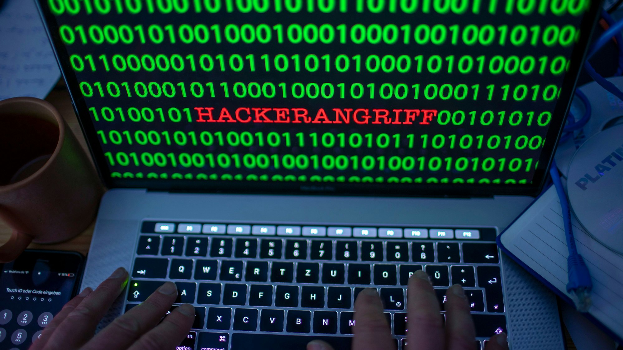 Zwischen dem Binärcode auf einem Laptopmonitor ist das Wort «Hackerangriff» zu sehen. (gestelltes Foto).