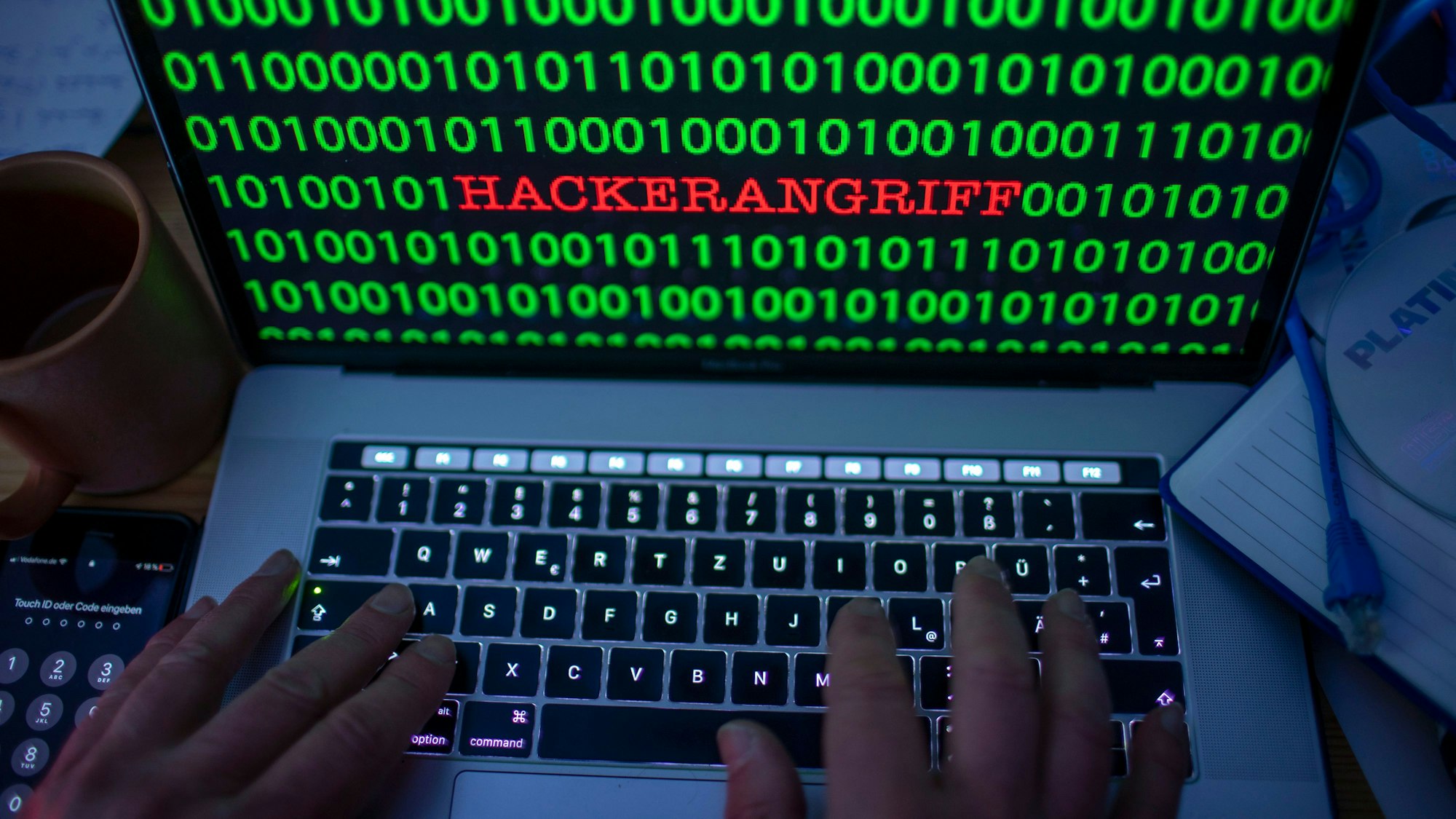 Eine Laptop-Tastatur, auf dem Bildschirm das Wort Hackerangriff