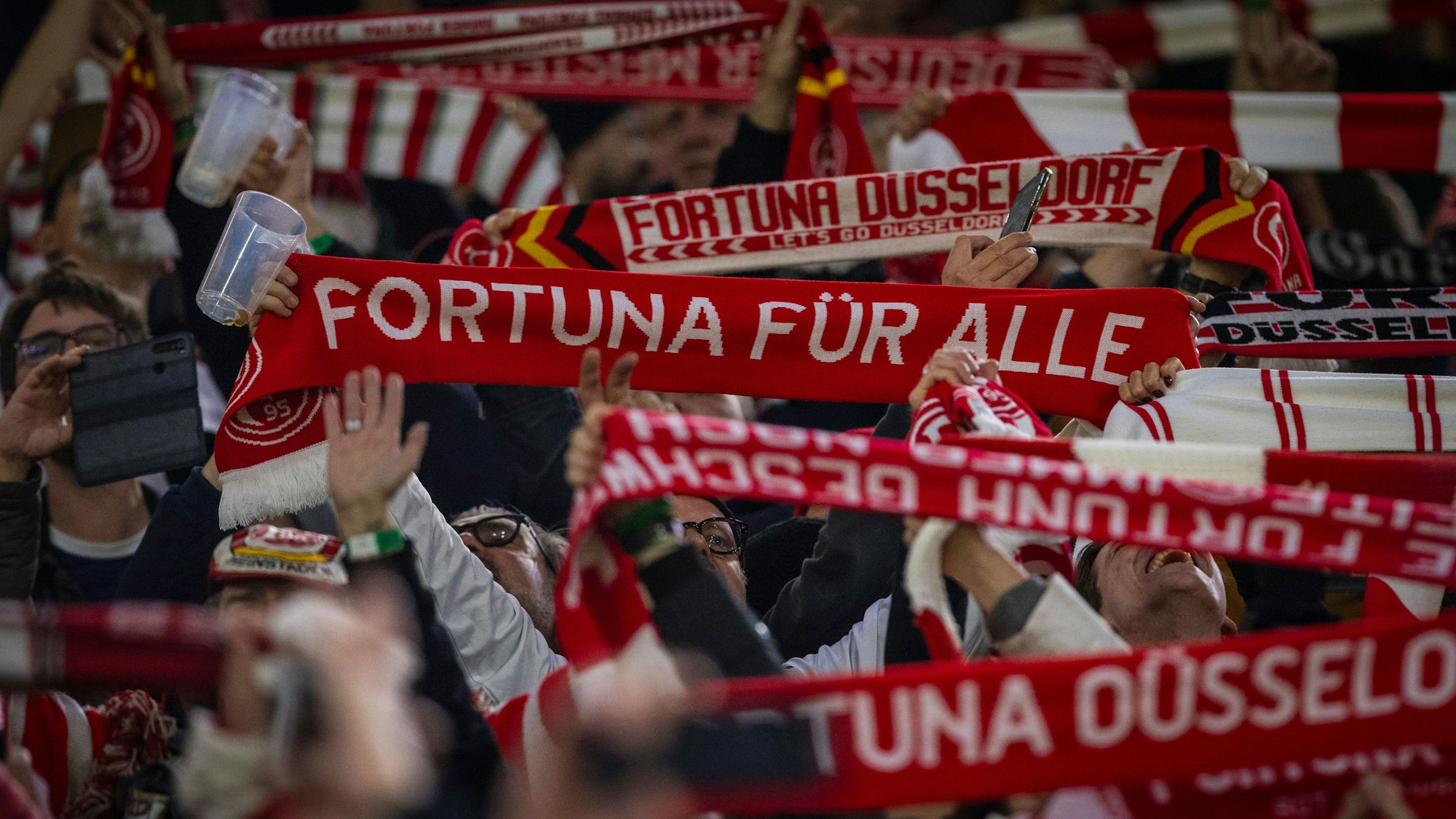 Fans von Fortuna Düsseldorf strecken beim Spiel gegen den 1. FC Kaiserslautern ihre Schals in die Höhe.
