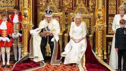 Königin Camilla, die das Staatsdiadem von George IV. trägt, sitzt neben dem britischen König Charles III., der die kaiserliche Staatskrone und den Staatsmantel trägt, während er vom Thron des House of Lords aus die Rede des Königs während der Eröffnung des Parlaments in den Houses of Parliament verliest.