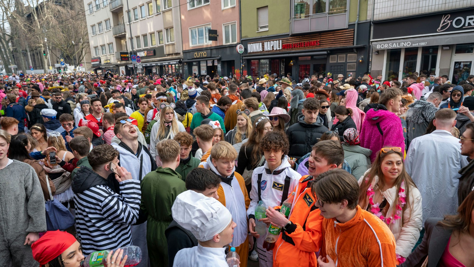 Viele Menschen feiern auf der Zülpicher Straße in Köln verkleidet an Karneval.