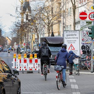 Radfahrer und ein Auto vor der Sperrung an der Kreuzung zur Piusstraße, wo die Venloer Straße zur Einbahnstraße wird