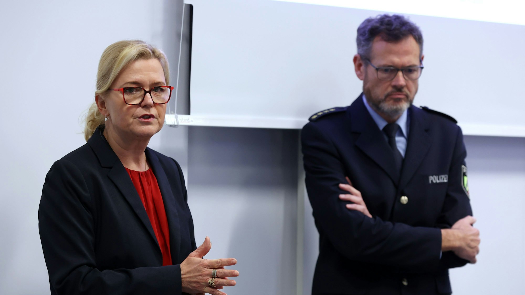 Miriam Brauns, stellvertretende Kölner Polizeipräsidentin, und Einsatzleiter Frank Wißbaum stehen unter einer Leinwand, auf der die Präsentation für den Einsatz gezeigt wird.
