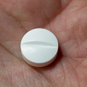 Auf der Hand einer Frau liegt eine Tablette, die den Wirkstoff Paracetamol enthält.&nbsp;