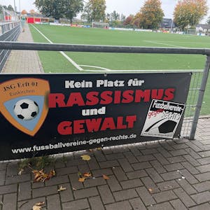 Das Bild zeigt ein Schild mit der Aufschrift „Kein Platz für Rassismus und Gewalt“ auf dem Sportplatz der JSG Erft in Kuchenheim.&nbsp;