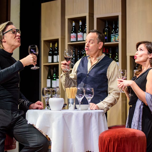 Martin Armknecht (l.), Moritz Lindbergh (m.) und Natalia Avelon (r.) verköstigen Wein in einer Szene des Theaterstücks „Weinprobe für Anfänger“.