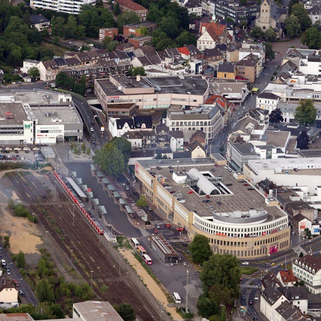Auf dem Luftbild ist das Geschäftshaus Rheinberg-Passage mit Parkhaus zu sehen. Die S-Bahn-Gleise grenzen unmittelbar an die Immobilie an.