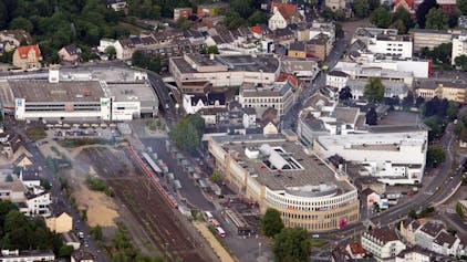 Auf dem Luftbild ist das Geschäftshaus Rheinberg-Passage mit Parkhaus zu sehen. Die S-Bahn-Gleise grenzen unmittelbar an die Immobilie an.