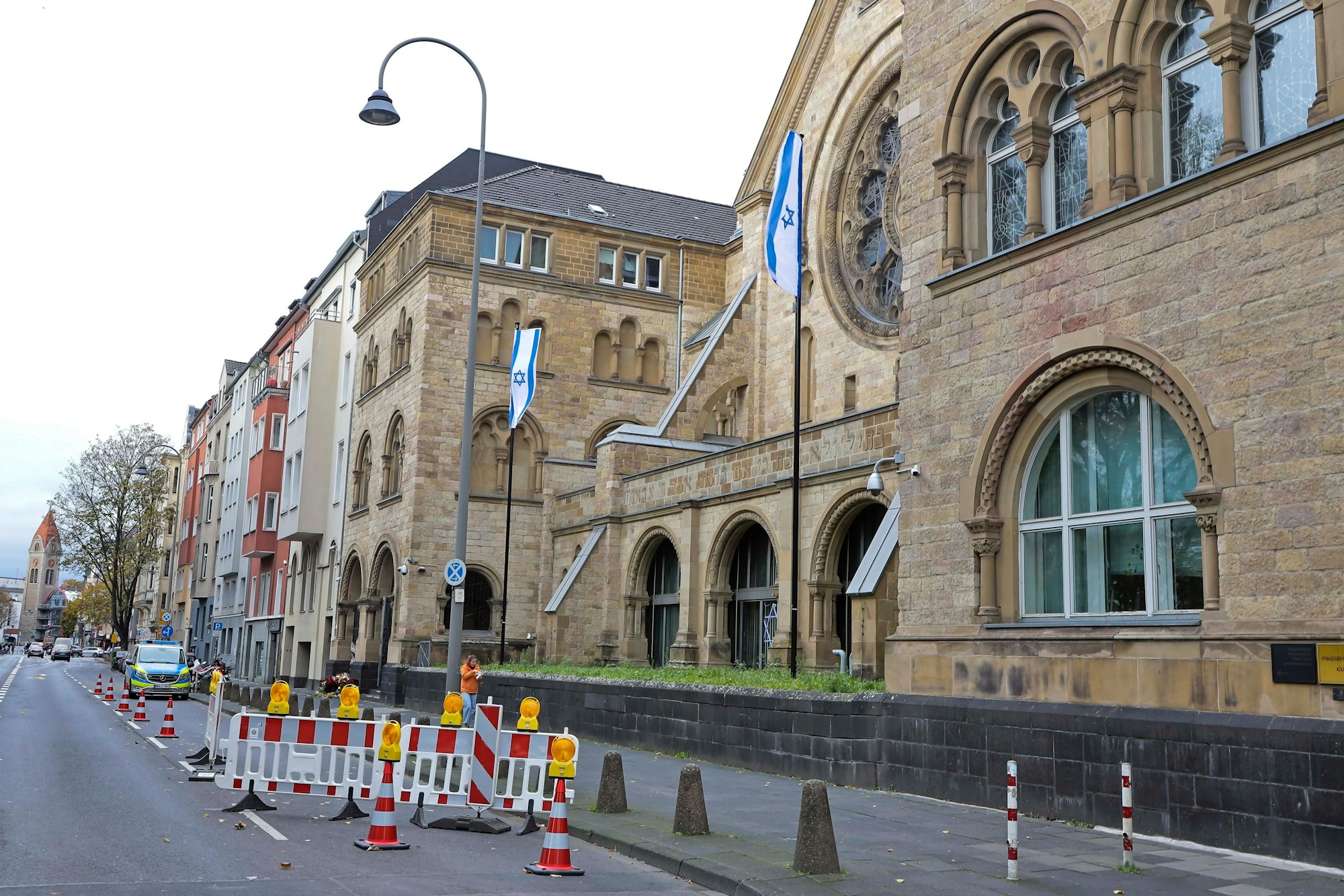 Außenansicht der Synagoge in Köln. Vor dem Gebäude steht ein Streifenwagen der Polizei.