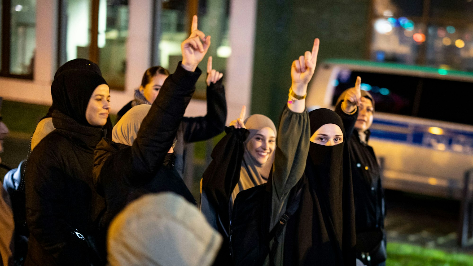 Frauen heben den Zeigefinger ihrer rechten Hand bei der Kundgebung „Gaza unter Beschuss - gemeinsam gegen das Unrecht“.
