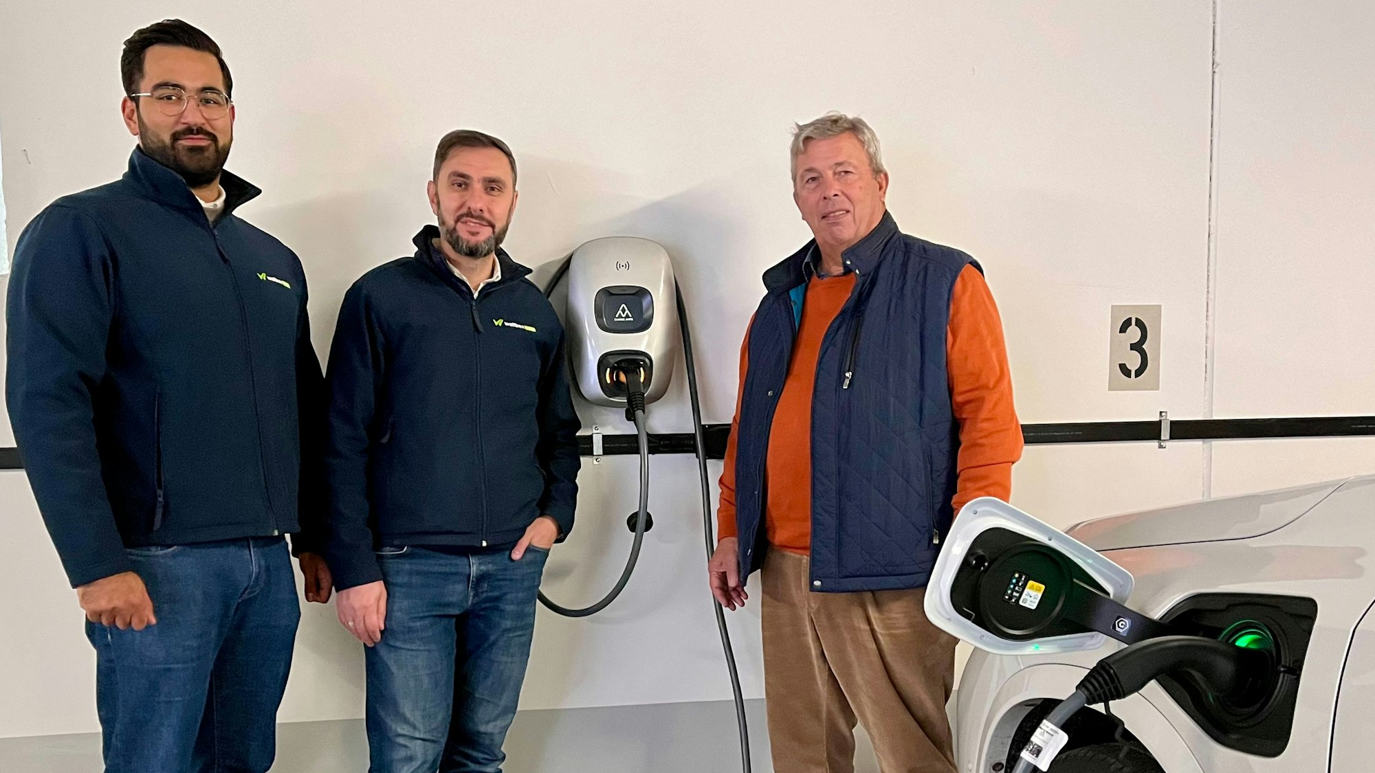 Alperen Bilal, Wallbox now-Gründer Tahsin Yigit und Ulrich Giesen an einer der Strom-Zapfstellen in der Tiefgarage des Hauses Mittelstraße 14 - 16 in Burscheid