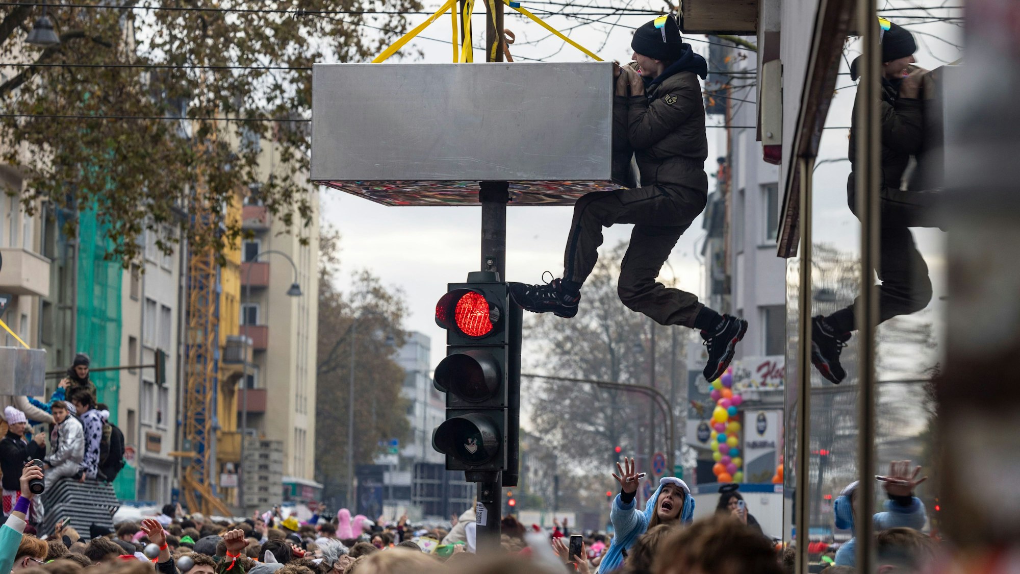Ein Mann klettert auf einer Straßenampel, die angebrachte Klettersperre hindert ihn nicht.