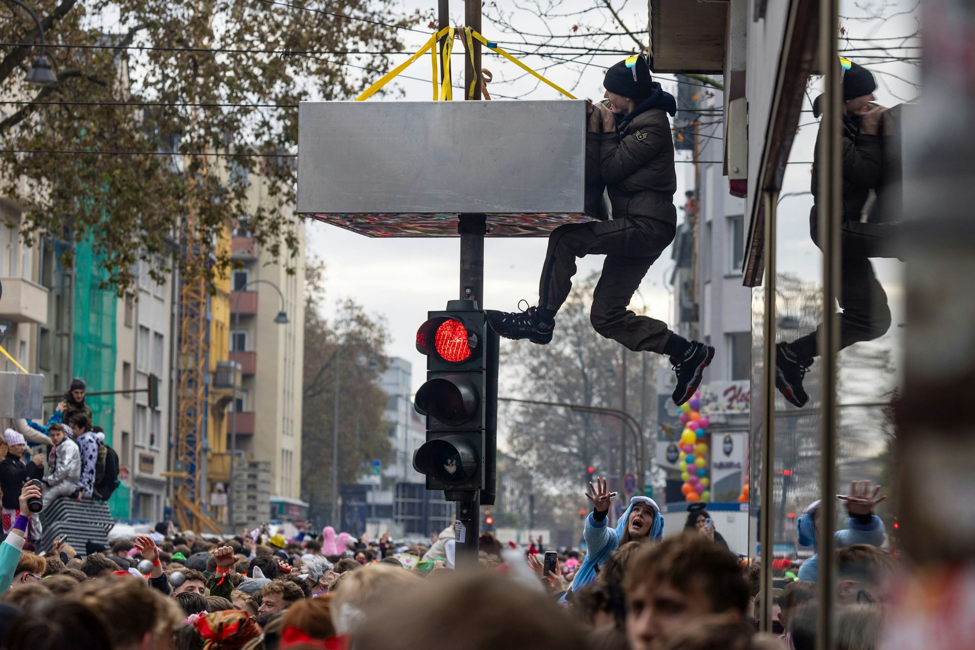 Ein Mann klettert auf einer Straßenampel, die angebrachte Klettersperre hindert ihn nicht.