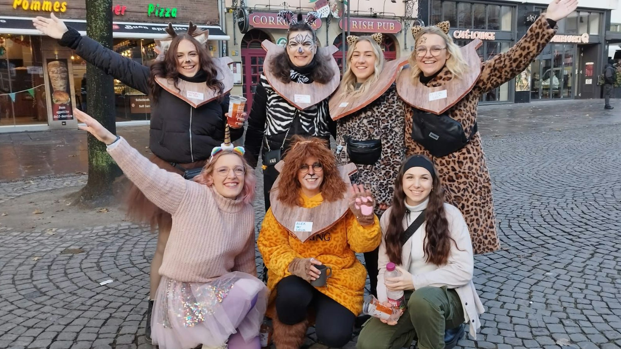 Sechs Frauen in Kostümen posieren für ein Gruppenfoto.