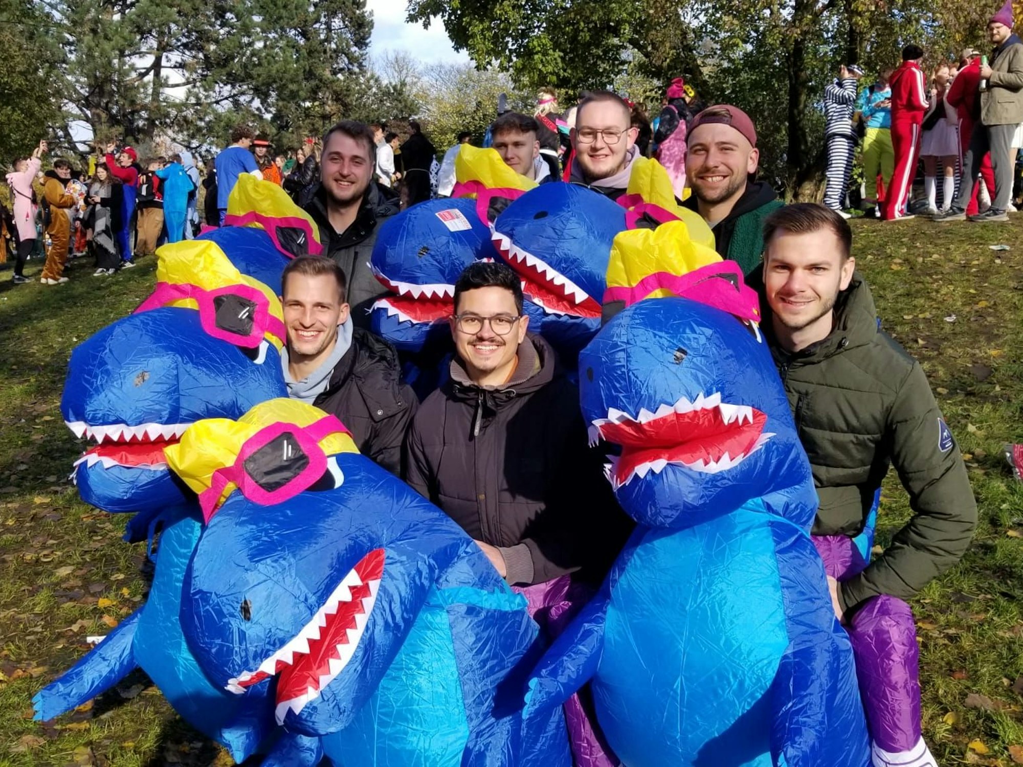 Sieben Freunde tragen im Karneval alle das gleiche Dino-Kostüm.