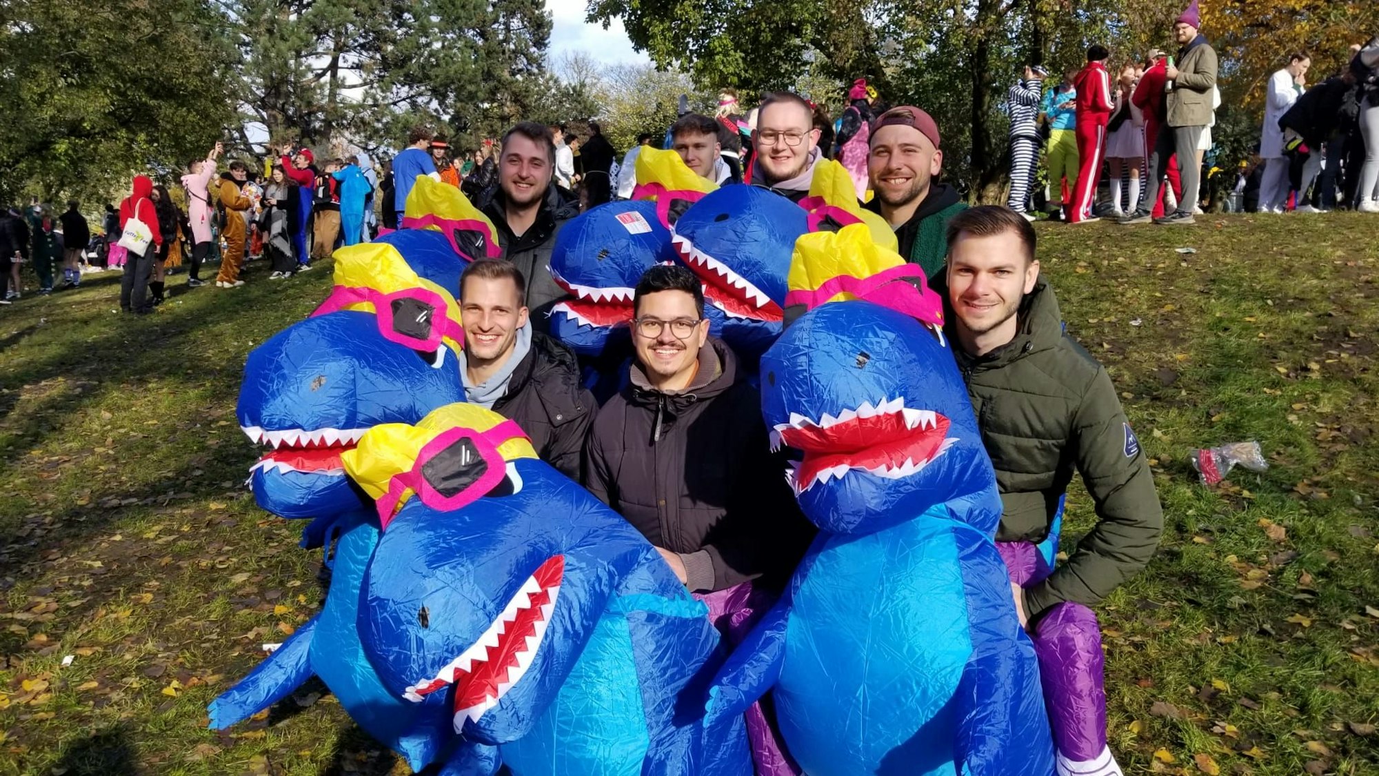 Sieben Freunde tragen im Karneval alle das gleiche Dino-Kostüm.