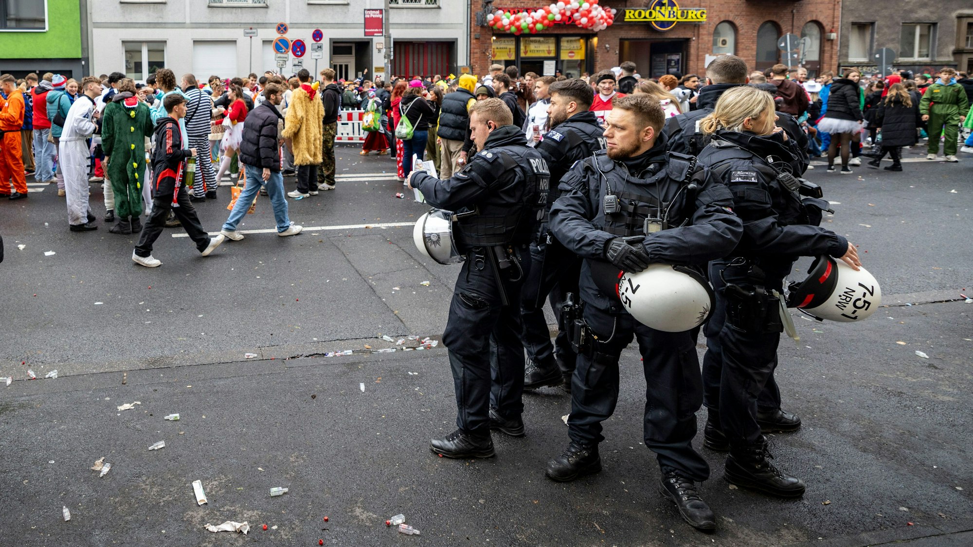 Mehrere Einsatzkräfte der Polizei beobachten auf der Roonstraße das Treiben am 11.11. in Köln.