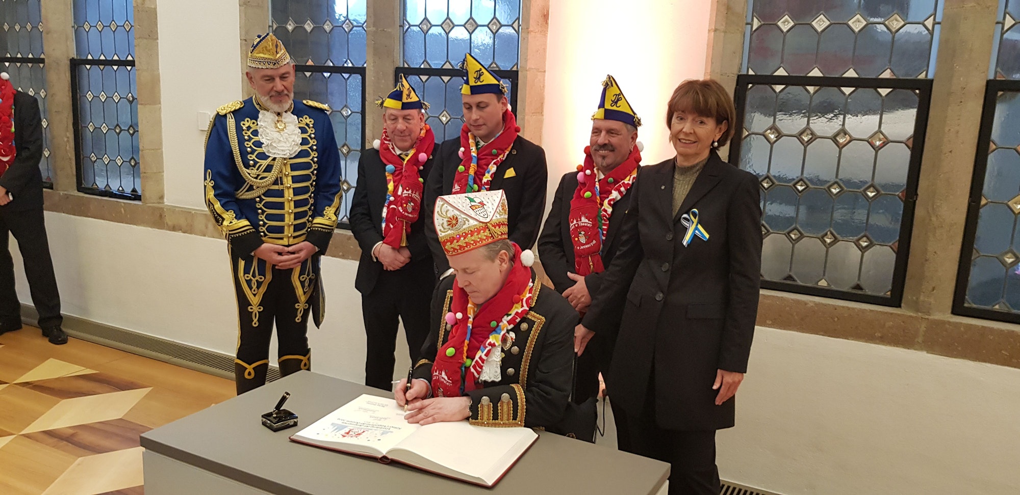 Das Dreigestirn der KG Treuer Husar und FK-Präsident Kuckelkorn tragen sich ins Gästebuch der Stadt ein.