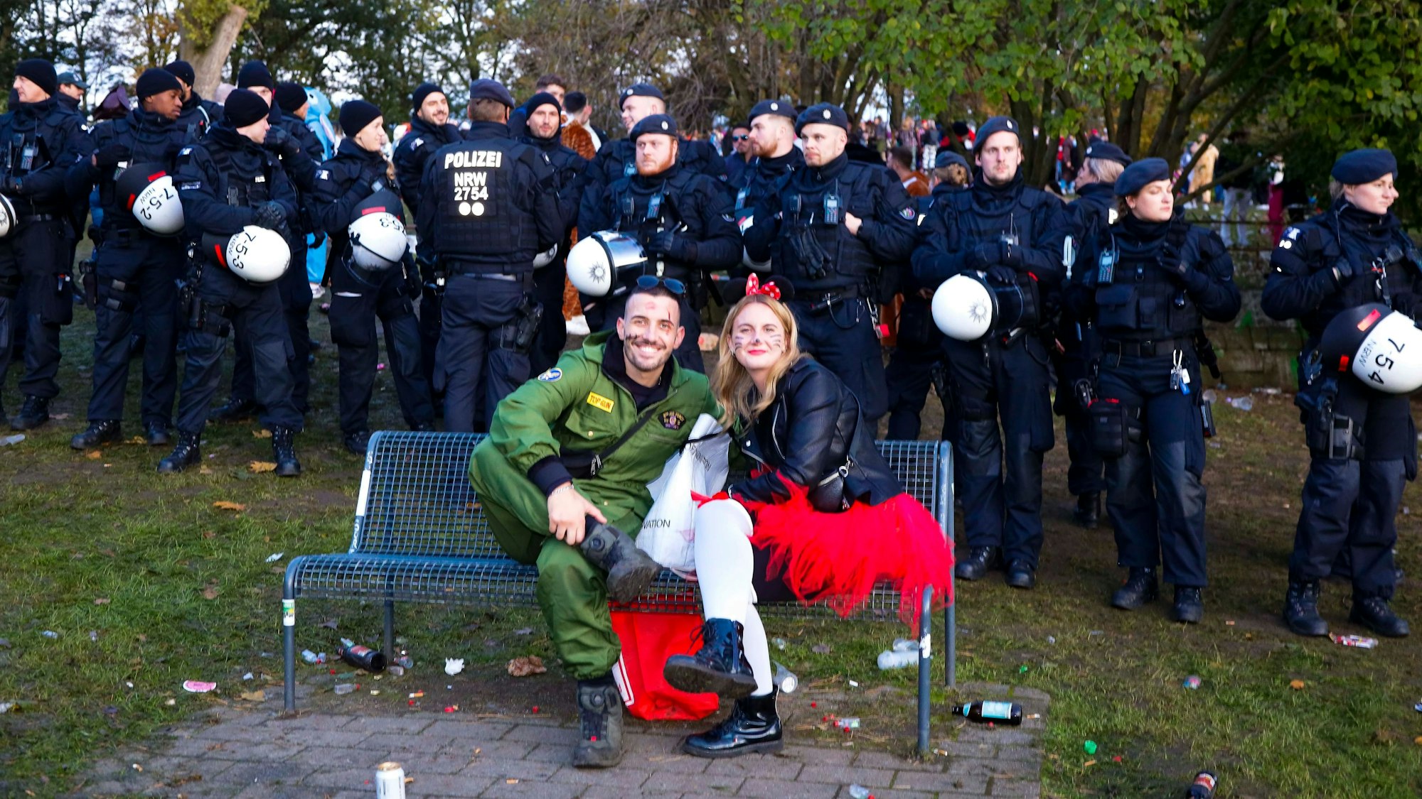 Kuriose Szene auch am Aachener Weiher: zwei Feiernde sitzen auf einer Bank, die Polizei ist mit einem massiven Aufgebot vor Ort.