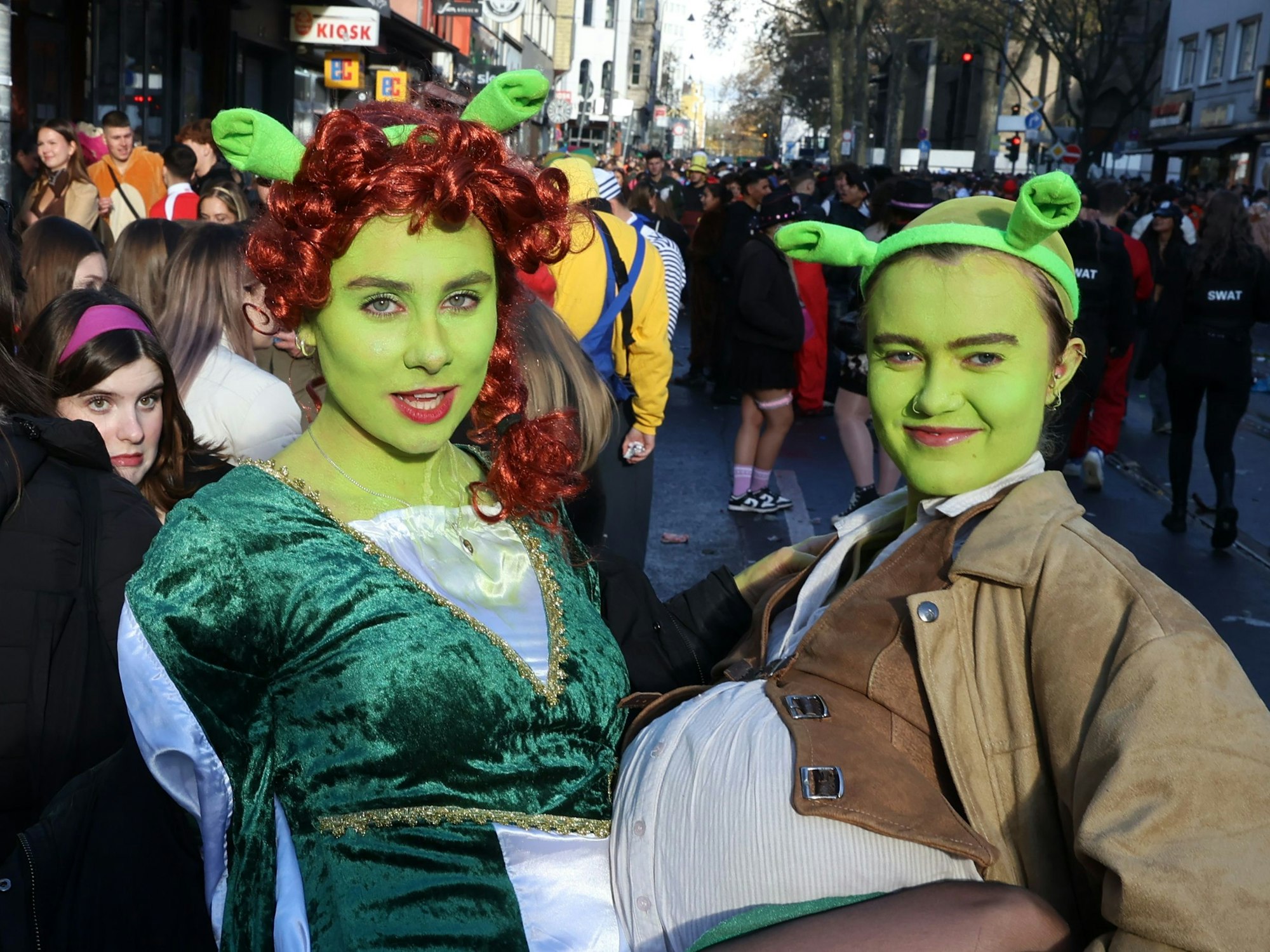 Zwei Frauen in grünen Kostümen posieren für die Kamera.