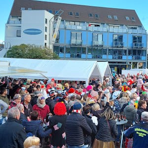 Viele bunt kostümierte Menschen stehen zum Karnevalsauftakt in Mechernich vor einer Bühne.