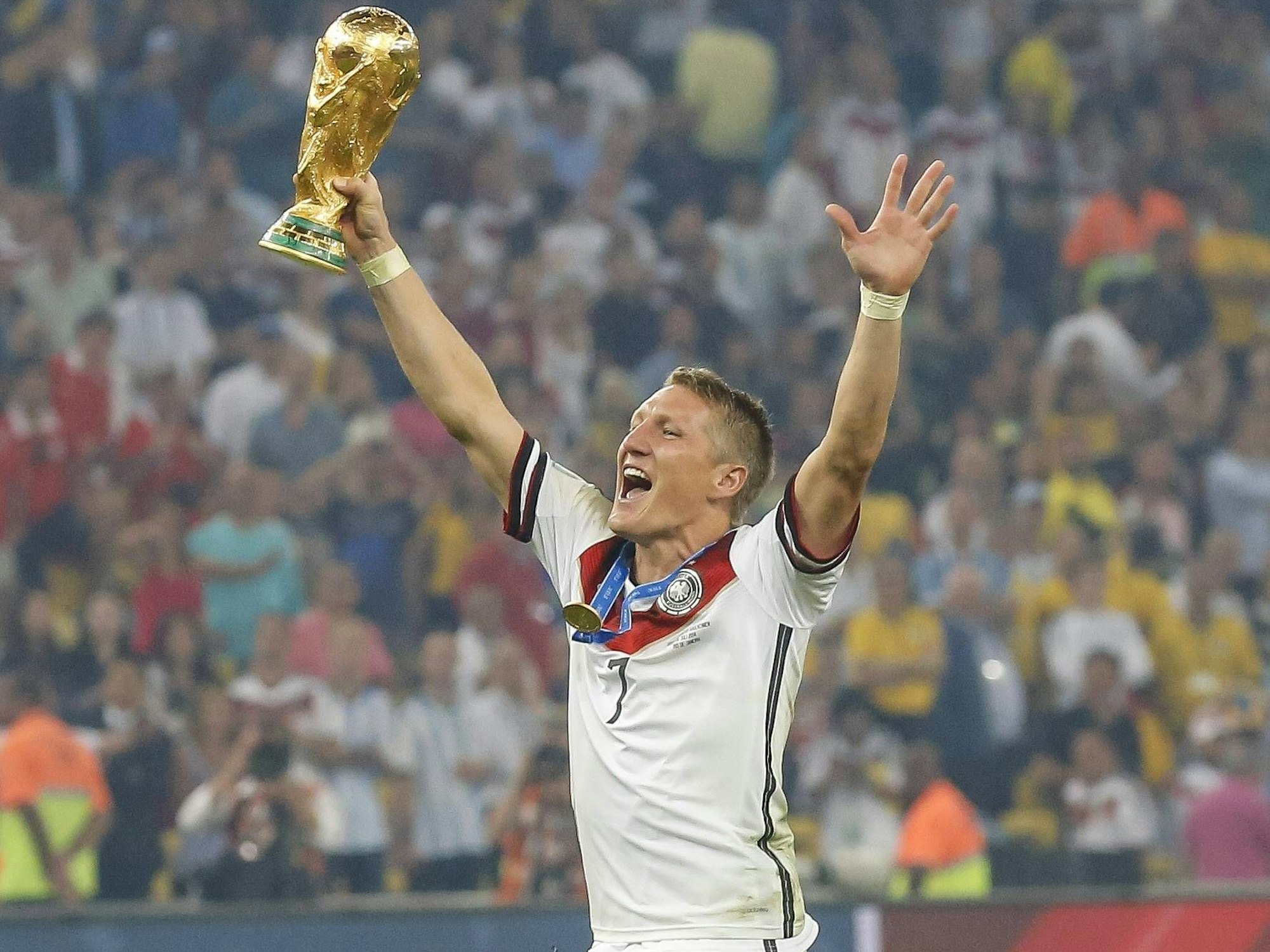 Bastian Schweinsteiger streckt jubelnd den WM-Pokal in die Höhe.
