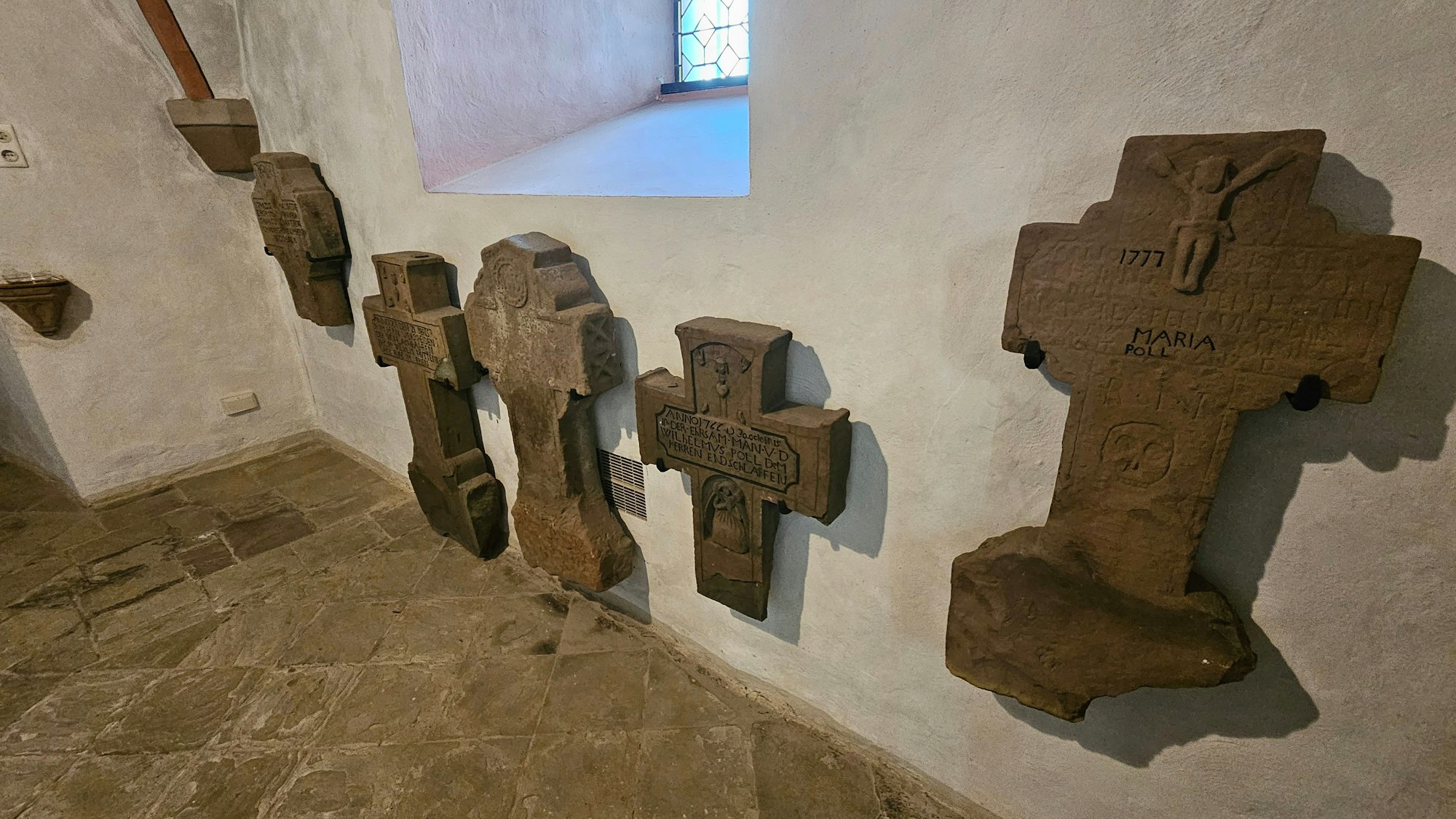 Alte Steinkreuze an der Wand des Turms sind zu sehen.