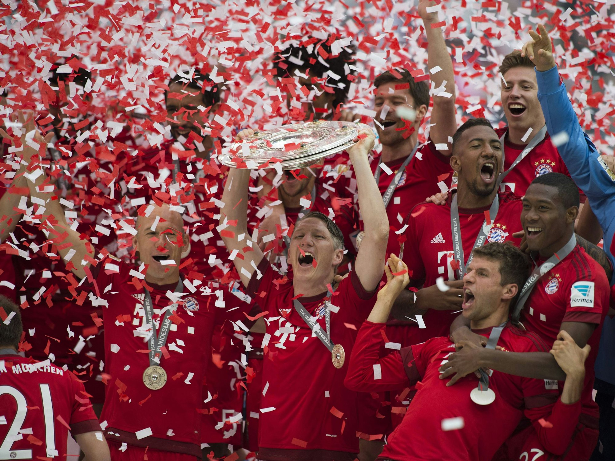 Bastian Schweinsteiger jubelt mit der Meisterschale. Die Bayern-Mannschaft feiert um ihn herum.