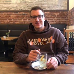 Junger Mann mit Ingwer-Tee im Café