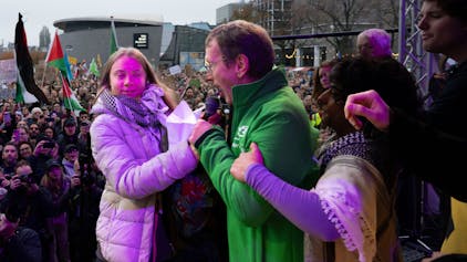Erjan Dam (M.) und Greta Thunberg streiten am Sonntag (12. November) bei der Klima-Demo in Amsterdam ums Mikrofon.
