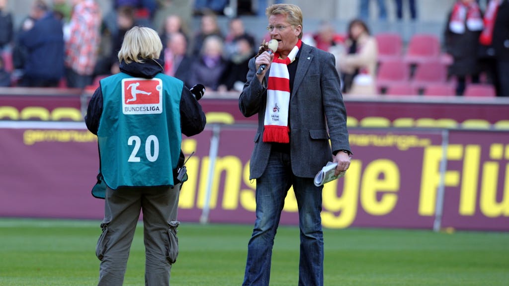 Stadionsprecher des 1. FC Kölns Michael Trippel steht mit Mikrofon in einem Fußball-Stadion.&nbsp;