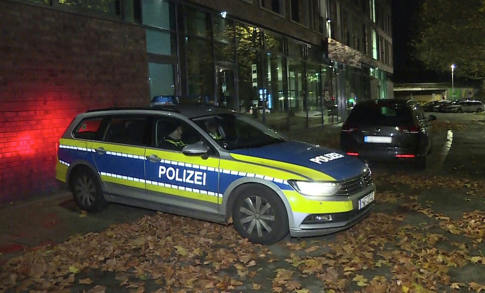 Ein Polizeifahrzeug stehen vor einem Hotel. Hier wurde ein Mann erstochen.