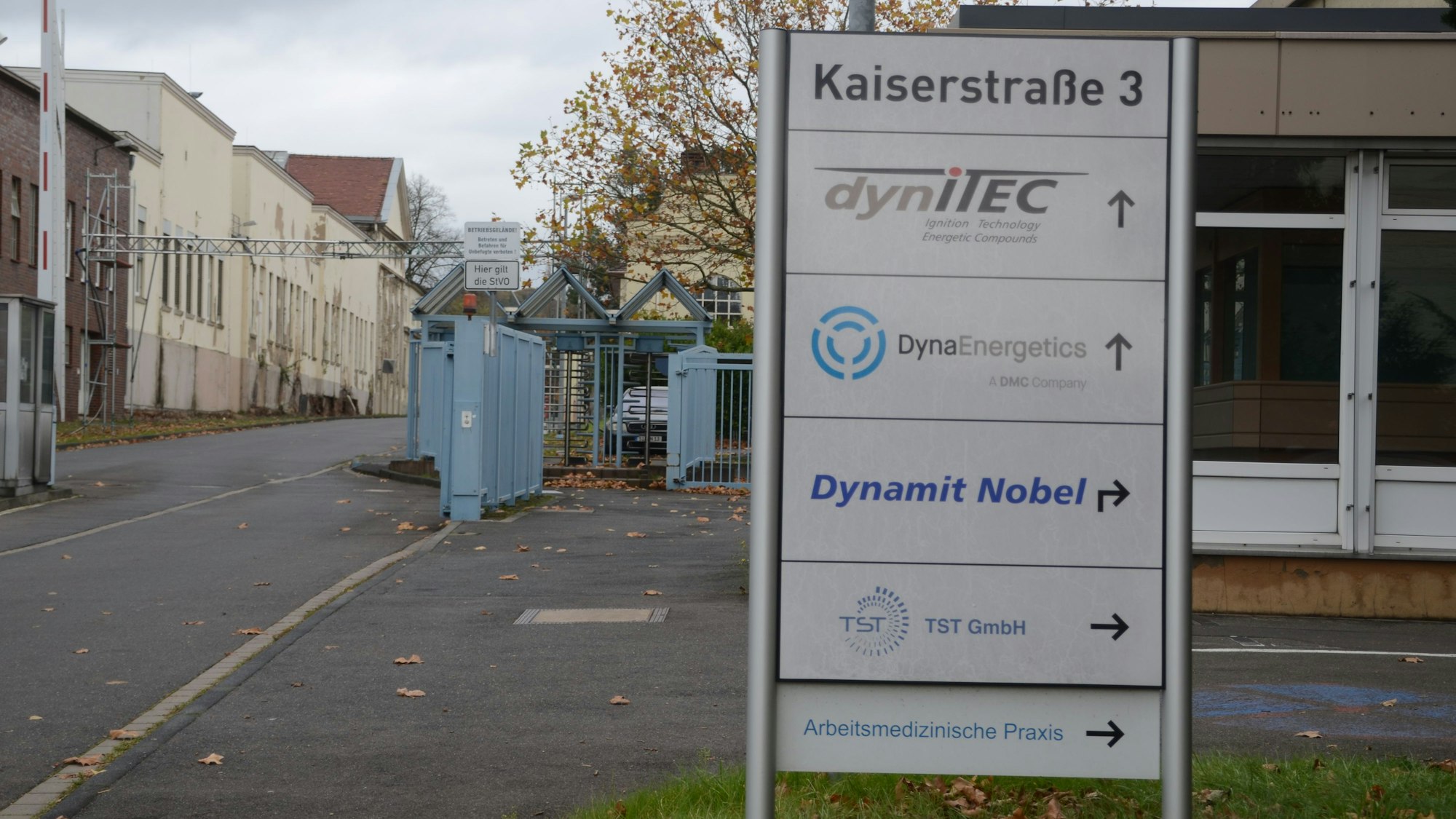 Das Tor zu einem Gewerbegebiet. Auf einem Schild steht die Adresse Kasierstraße 3; darunter sind die Namen von Firmen aufgelistet.