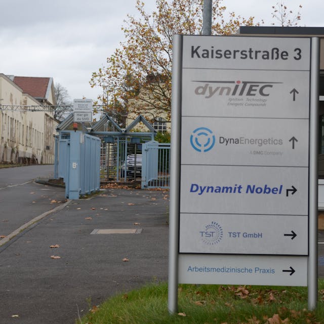 Das Tor zu einem Gewerbegebiet. Auf einem Schild steht die Adresse Kasierstraße 3; darunter sind die Namen von Firmen aufgelistet.
