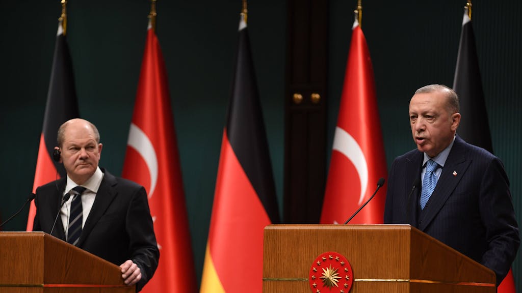 Olaf Scholz schaut grimmig in Richtung von Recep Tayyip Erdogan.