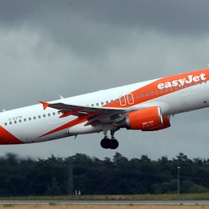 Ein Airbus A320 der britischen Fluggesellschaft Easyjet im Landeanflug während eines Unwetters. Das Flugzeug ist weiß-orange lackiert. (Symbolbild)
