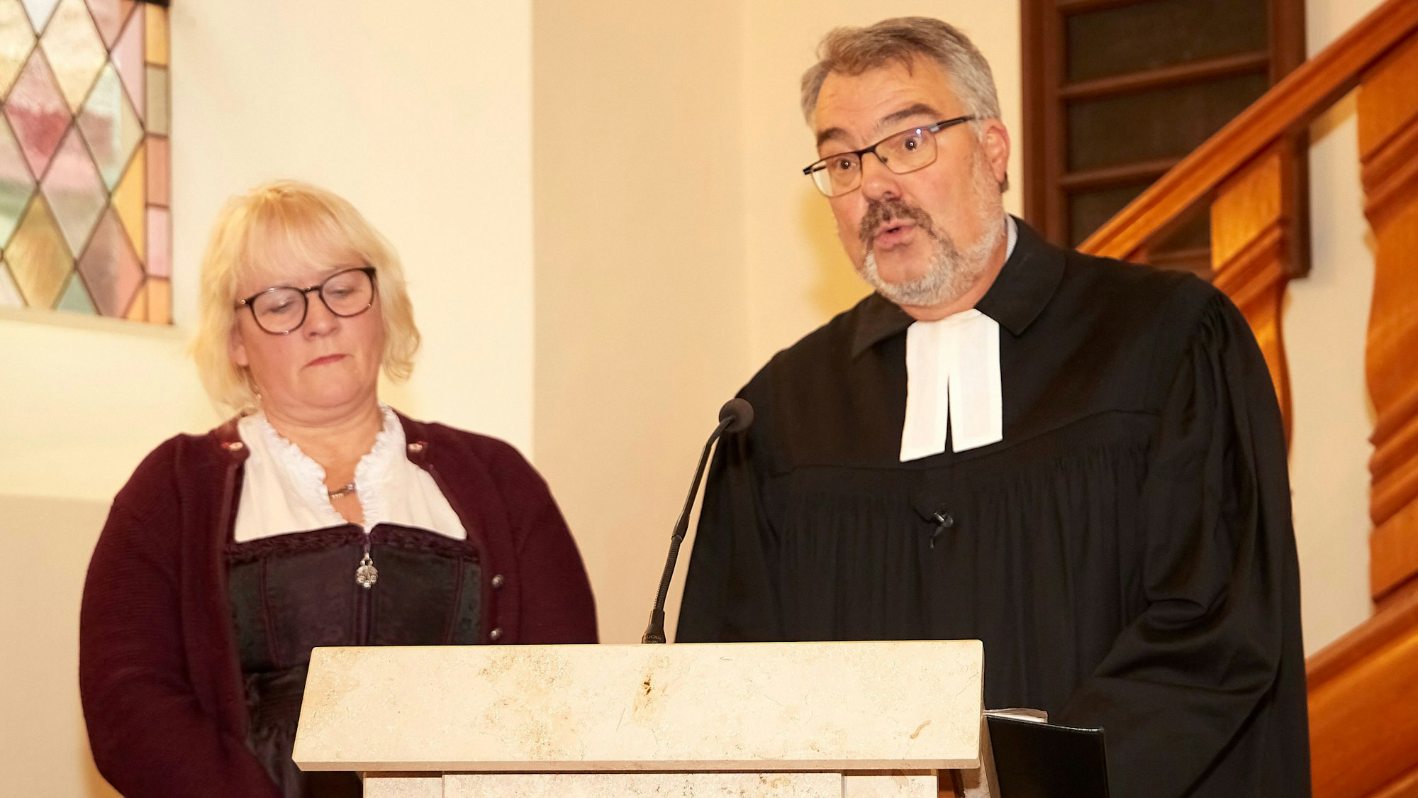 Ehefrau Heike und Pfarrer Erik Schumacher am Rednerpult in der Kirche.