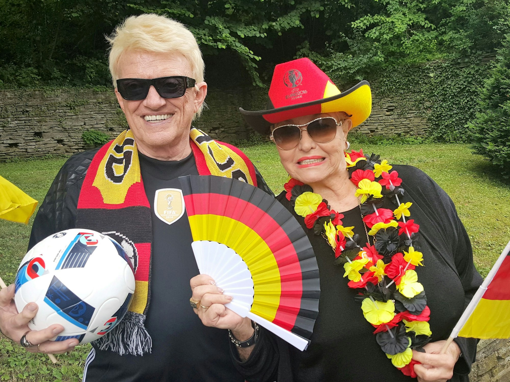 Das Bild zeigt Heino und Hannelore mit Deutschland-Fanartikeln. Heino hält zudem einen Ball im Arm.