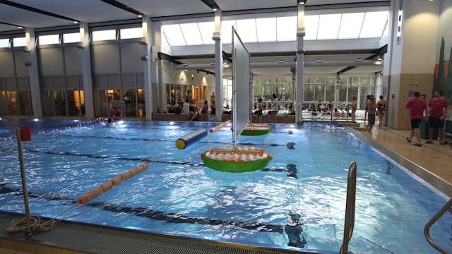 Das Aquarena-Hallenbad in Neunkirchen: Wasser glitzert im Becken, Menschen stehen am Beckenrand.